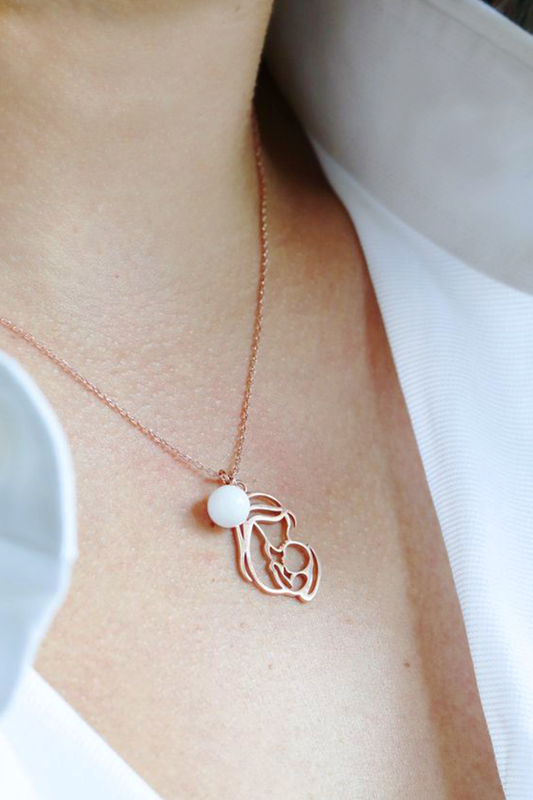 Mom holds her baby necklace